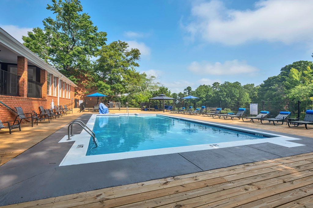 a swimming pool in front of a brick building with a resort style pool